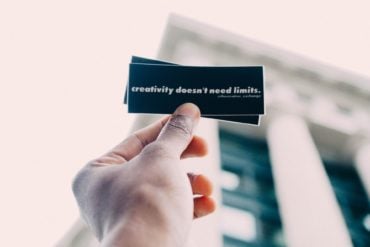 Person holding small card which says 'creativity doesn't need limits'