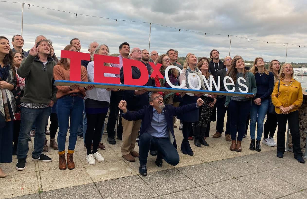 People taking part in TEDx Cowes holding TEDx Cowes banner