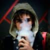 Young person vaping with lots of smoke around their face