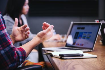 people using laptops at meeting table