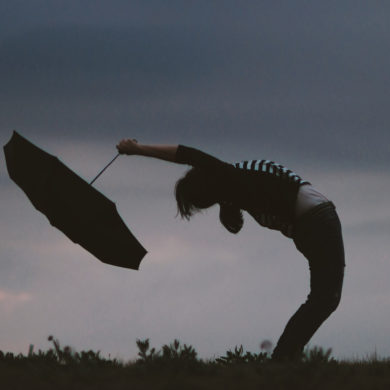 person bent backwards with umbrella in the wind