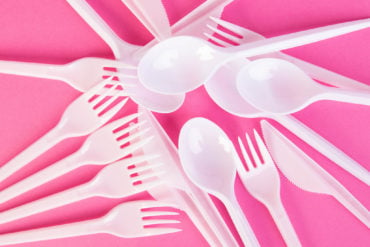 plastic cutlery on pink background