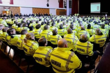 Lots of police sitting in a hall