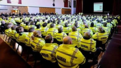 Lots of police sitting in a hall