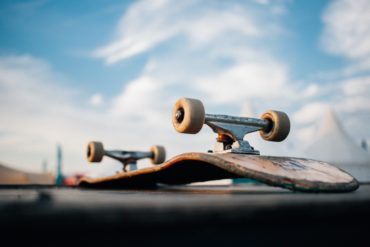 upside down skateboard on ramp with blue sky in background