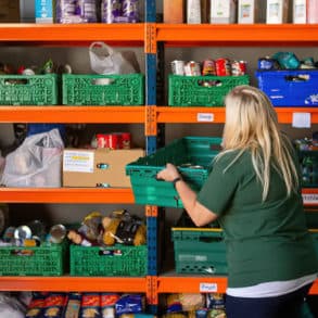 volunteer stacking shelves in foodbank