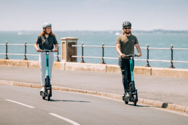 People on e-scooters along Cowes-Gurnard esplanade