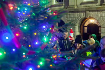 People looking at the Christmas Tree in Newport with the lights switched on - new