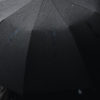 Person under black umbrellas by craig whitehead