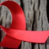 World Aids Day red ribbon on wooden surface