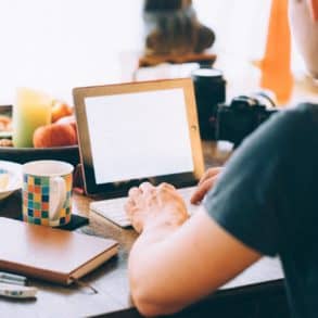 person sat at table on laptop