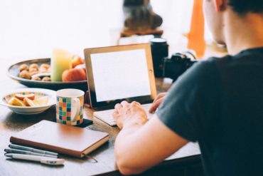 person sat at table on laptop