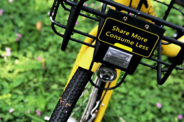 Bicycle with message 'share more and consume less' on the front of it
