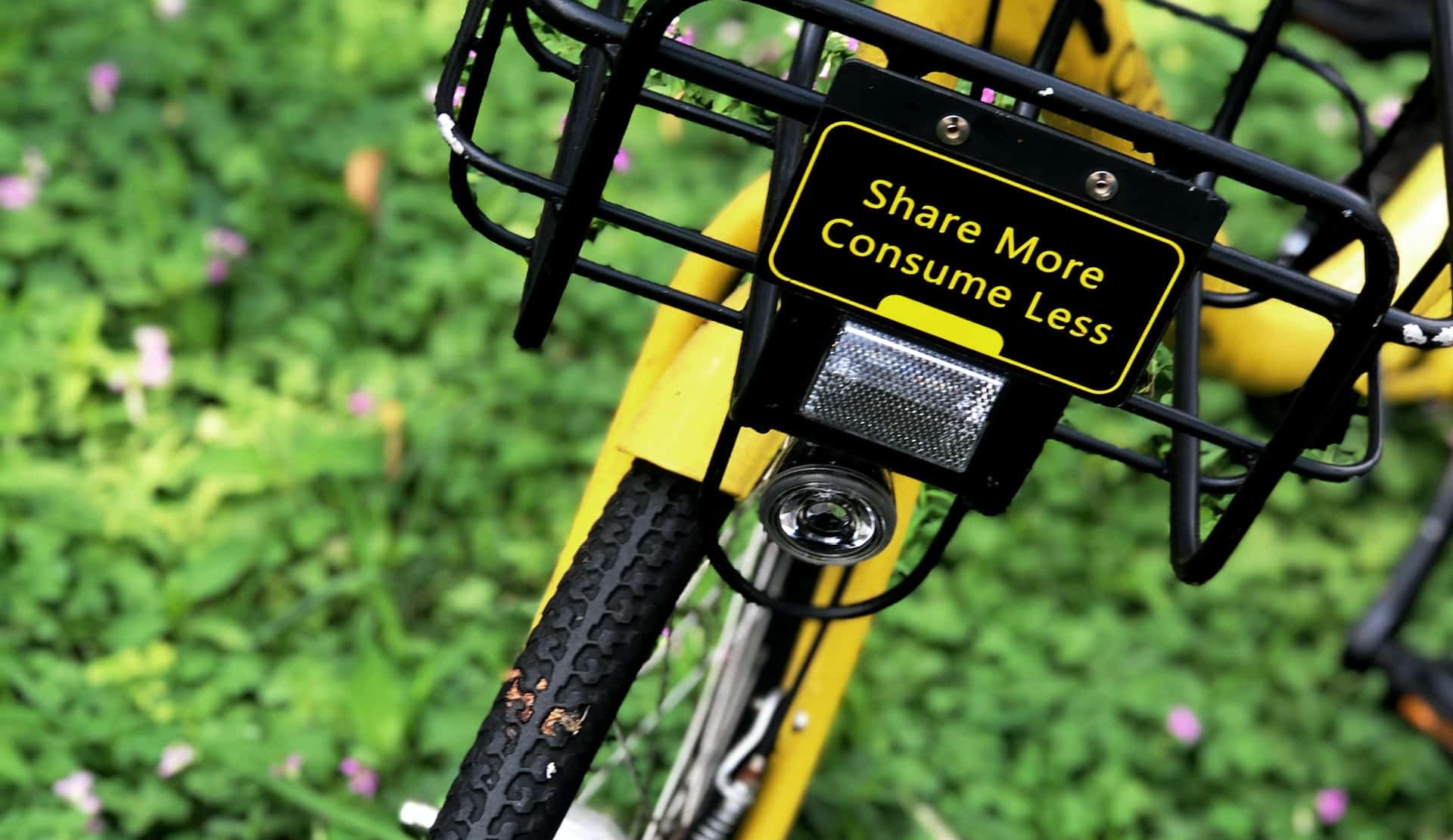 Bicycle with message 'share more and consume less' on the front of it