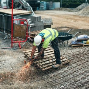 Man working on building site, cutting steel caging by emma houghton