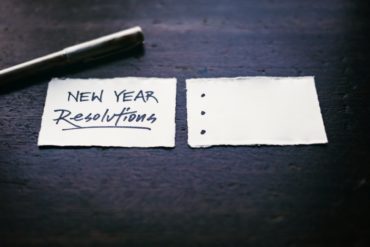 Pen and paper, with News Year Resolutions written on it