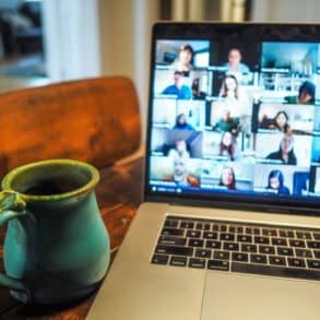 laptop open on table with zoom meeting on screen