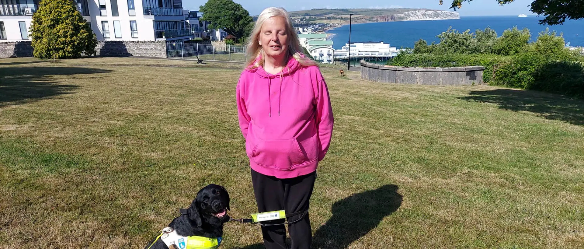 Emily brothers and her guide dog, Truffle, with View of Sandown Bay in the background