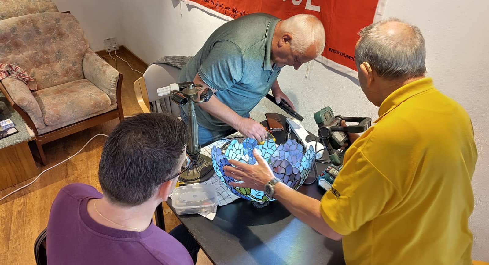 Men repairing a lamp at the Repair Cafe