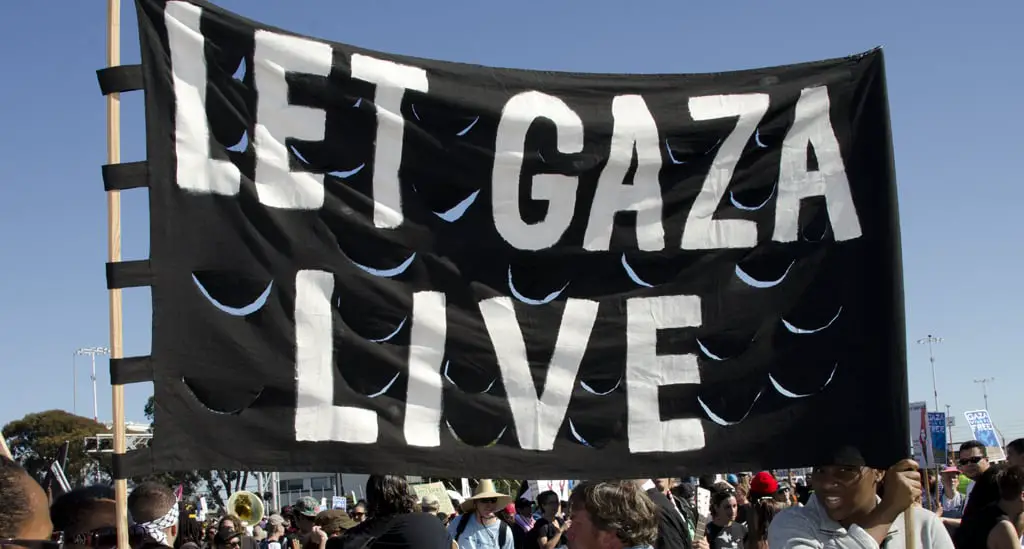 People at rally holding a 'Let Gaza Live' banner