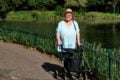 Woman with walking aid in the park by a pond