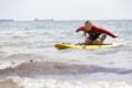 Young female beach lifeguard on a surf board