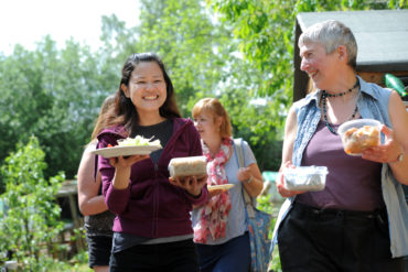 Masefield Community Garden in Northfield, B'ham with local resident and volunteer carrying food