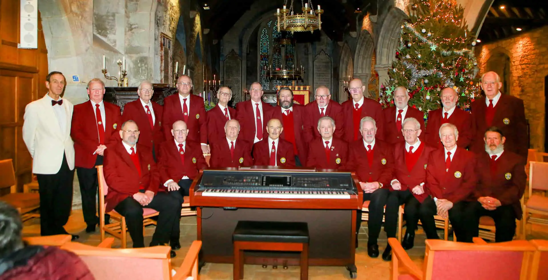 Newchurch Male voice choir standing around an organ