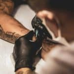 Tattooist working on someone's arm