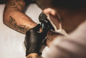Tattooist working on someone's arm