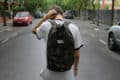 Teenage boy walking down the road with back to camera