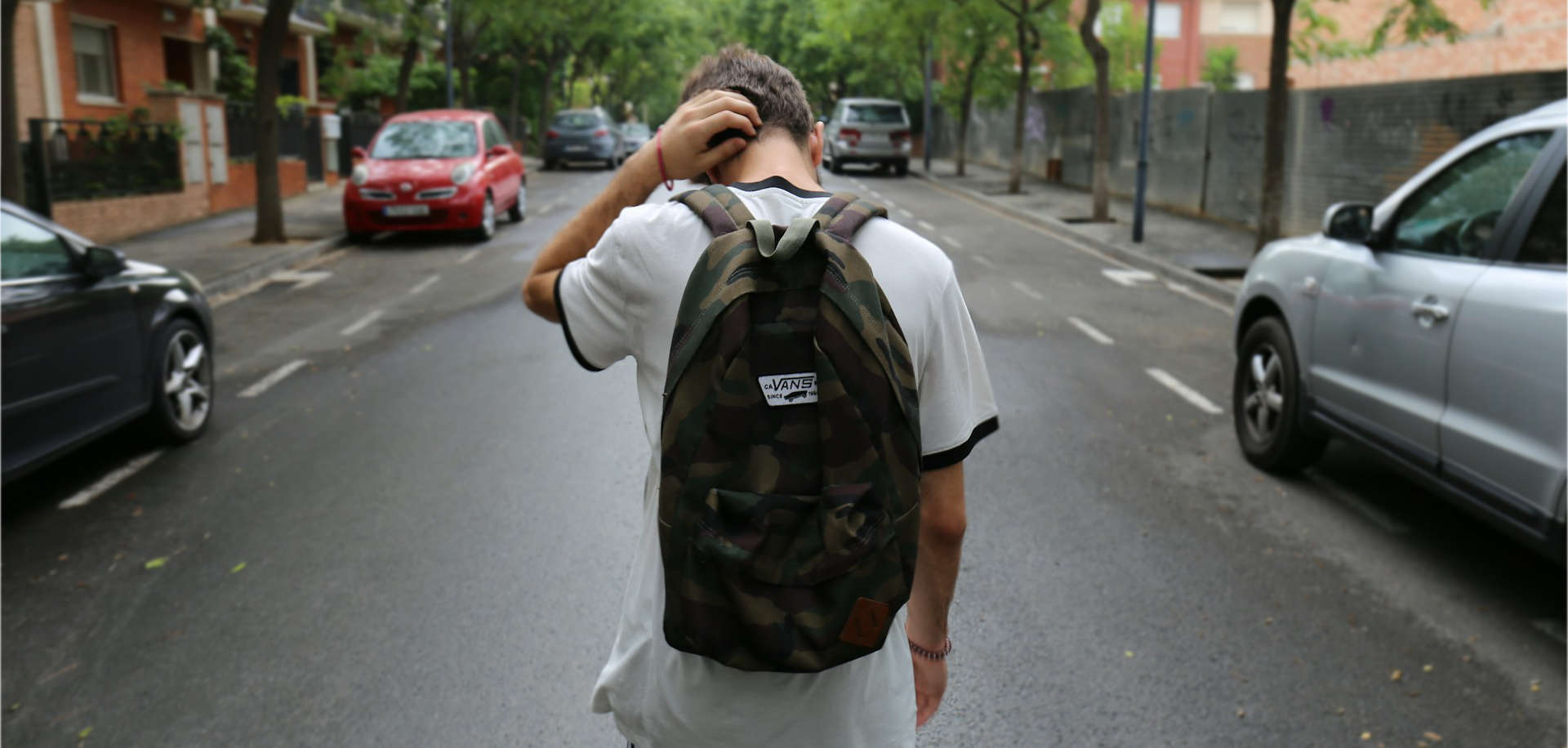Teenage boy walking down the road with back to camera