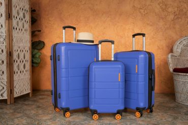 Three blue suitcases and hat by american green travel