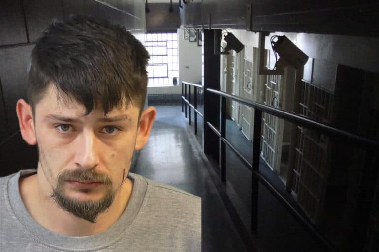 Mug shot of Paul Bishton against backdrop of jail corridor