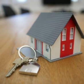 model of a house and set of keys on table