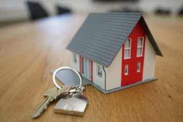 model of a house and set of keys on table