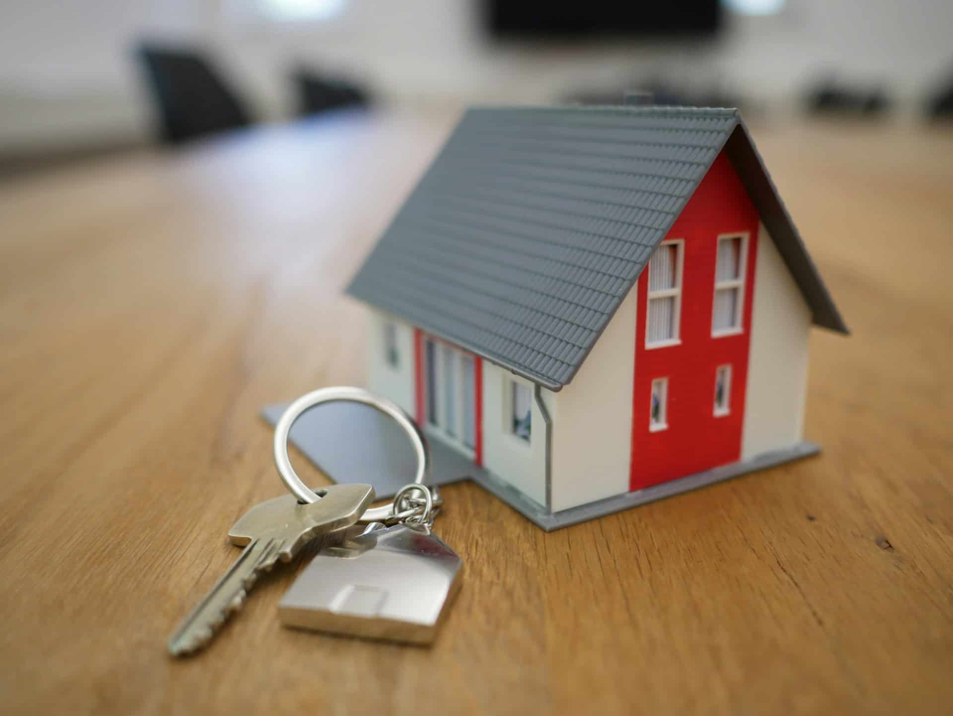 model of a house and set of keys on table