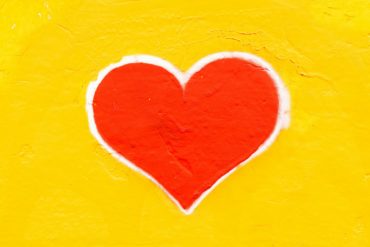 red heart painted on yellow wall