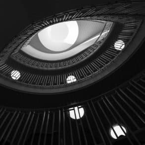 view from bottom of swirling staircase with spotlights on each level