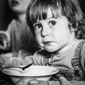 Child eating soup in black and white