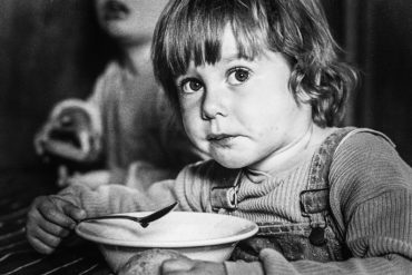Child eating soup in black and white