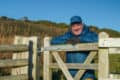 David Howarth standing by a country gate