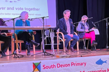 South Devon Primary town hall meeting with candidates and speaker on stage