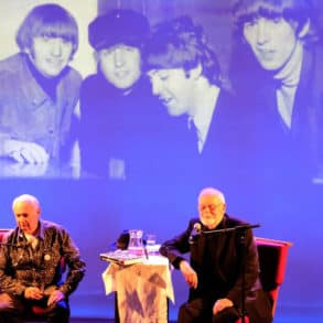 bob harris and Colin Hall on stage with photo of the beatles projected behind them