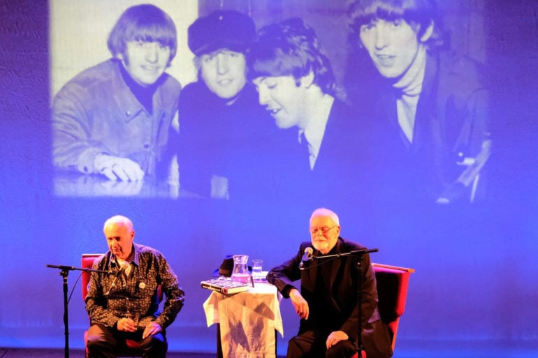 bob harris and Colin Hall on stage with photo of the beatles projected behind them