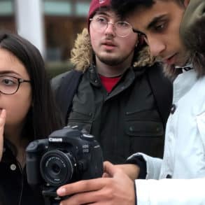 three young people using camera