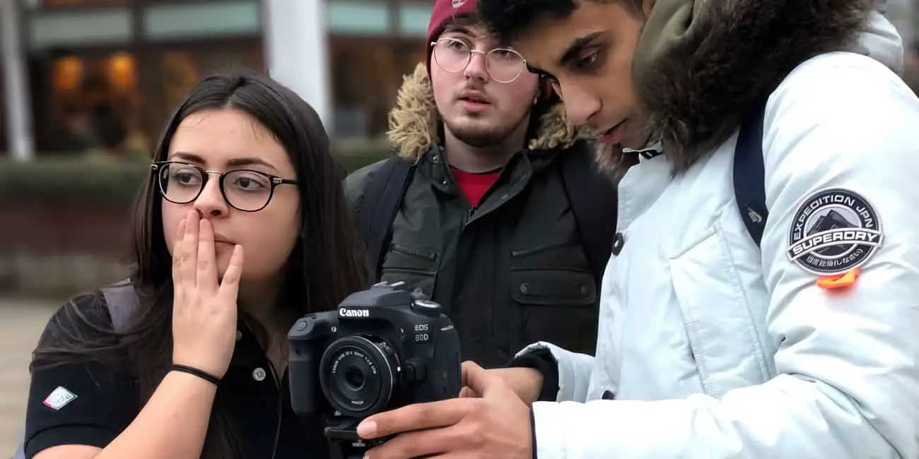 three young people using camera
