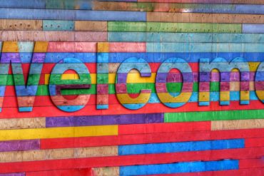welcome written in different coloured wood on wooden building