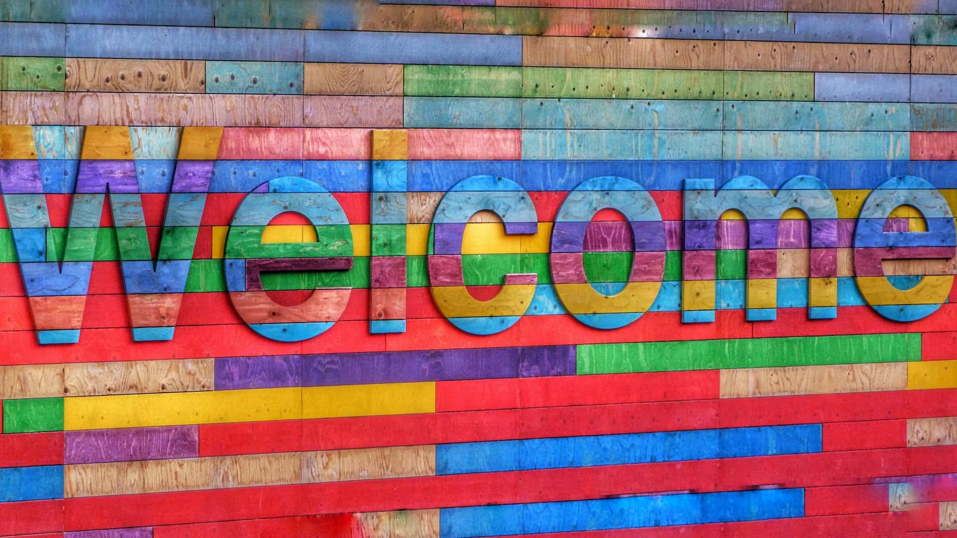 welcome written in different coloured wood on wooden building