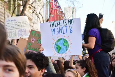 Climate change campaigners on march with banner reading there is no planet B